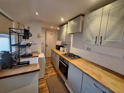 a kitchen with white cabinets and a counter top at Room in Stowmarket in Stowmarket