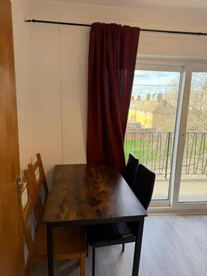 a table and chairs in a room with a window at Cozy 3 Bedroom Flat near Essex Uni, WiFi and Free Parking in Hythe