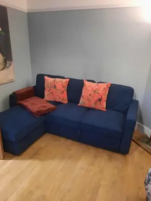 a blue couch with two pillows on it in a room at The Grantchester - Charming 20th Century Home in Barton