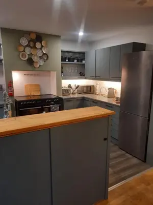 a kitchen with a counter top and a refrigerator at The Grantchester - Charming 20th Century Home in Barton