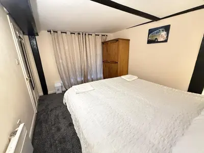 a bedroom with a white bed and a window at Comfort zone in Colchester
