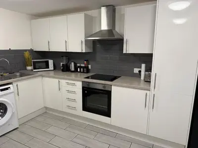 a kitchen with white cabinets and a stove top oven at Comfort zone in Colchester