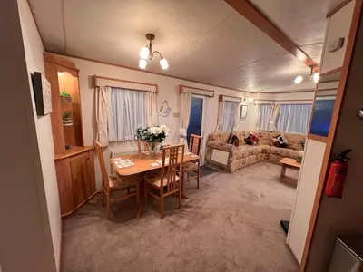 a living room with a table and a couch at A & C Coastal Hideaway with outside Decking in East Mersea