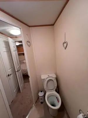 a small bathroom with a toilet and a door at A & C Coastal Hideaway with outside Decking in East Mersea