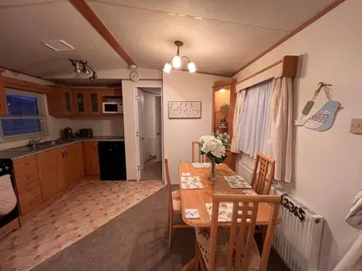 a kitchen and dining room with a table and chairs at A & C Coastal Hideaway with outside Decking in East Mersea