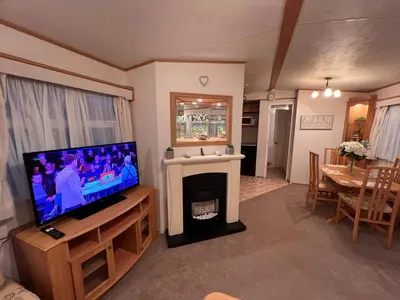 a living room with a television and a fireplace at A & C Coastal Hideaway with outside Decking in East Mersea