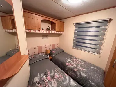 a small room with two beds and a window at A and C Coastal Hideaway Private Decking in Colchester