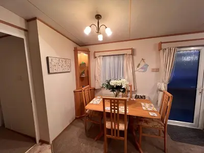a dining room with a table and chairs and a window at A and C Coastal Hideaway Private Decking in Colchester