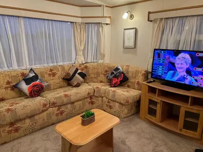 a living room with a couch and a flat screen tv at A and C Coastal Hideaway Private Decking in Colchester