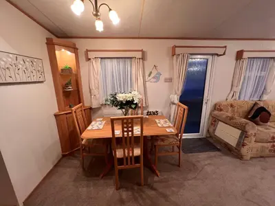 a living room with a table and a chair and a couch at A and C Coastal Hideaway Private Decking in Colchester