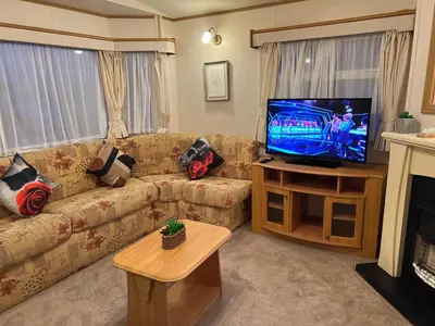 a living room with a couch and a flat screen tv at A and C Coastal Hideaway Private Decking in Colchester