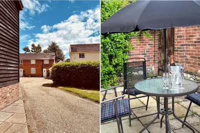a table with an umbrella and a table with glasses on it at 2 Bed in Scole oc-p34354 in Scole