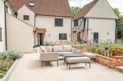 a patio with a couch and a table and chairs at 11 Bed in Stebbing oc-p34450 in Stebbing