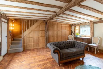 a living room with a couch and a staircase at 11 Bed in Stebbing oc-p34450 in Stebbing