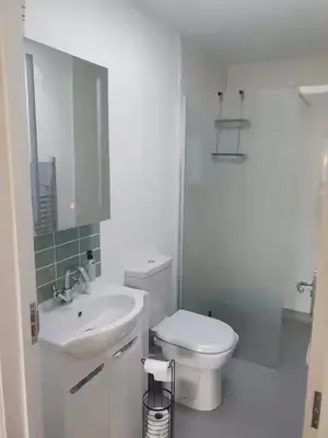 a white bathroom with a toilet and a sink at Ensuite Room with Private Entrance in St Ives
