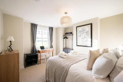 a bedroom with a white bed and a desk at 7 Highbury Cottages, Leiston in Leiston