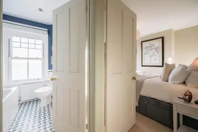 a bedroom with a bed and a bathroom with a toilet at 7 Highbury Cottages, Leiston in Leiston