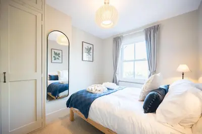 a bedroom with a bed and a large window at 7 Highbury Cottages, Leiston in Leiston