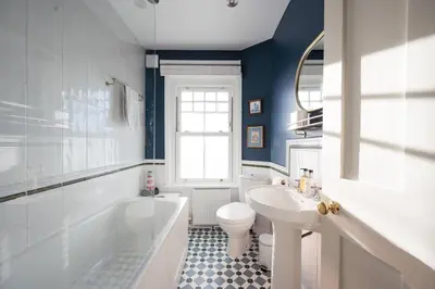 a bathroom with a toilet and a tub and a sink at 7 Highbury Cottages, Leiston in Leiston