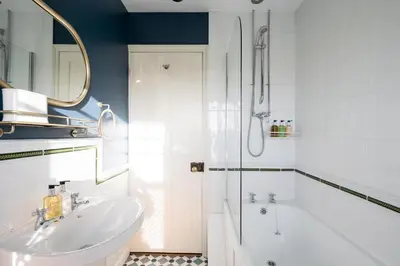 a bathroom with a tub and a sink and a shower at 7 Highbury Cottages, Leiston in Leiston