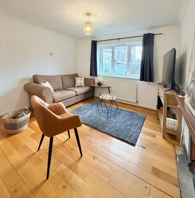 a living room with a couch and a tv at Stylish 3BR Cambridge Bungalow, Near Science Park in Cambridge