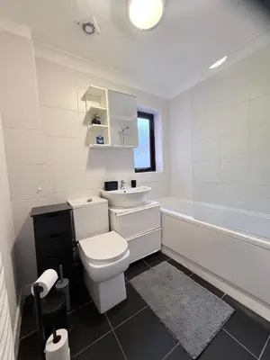a bathroom with a toilet and a sink and a tub at Stylish 3BR Cambridge Bungalow, Near Science Park in Cambridge