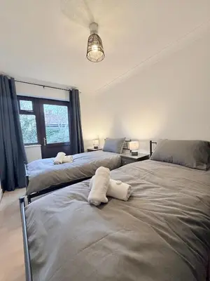 two beds sitting next to each other in a bedroom at Stylish 3BR Cambridge Bungalow, Near Science Park in Cambridge