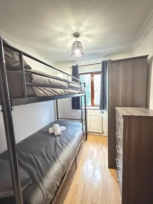 a bedroom with two bunk beds and a desk at Stylish 3BR Cambridge Bungalow, Near Science Park in Cambridge