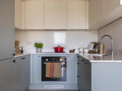 a kitchen with white cabinets and an oven at Charles Hope Cambridge in Cambridge