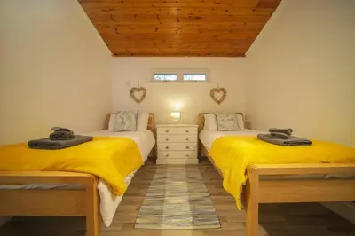 two beds in a room with yellow sheets at A12 & A14 Location - Suffolk IP3 - Secure Parking x3 in Nacton