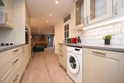 a kitchen with white cabinets and a washer and dryer at Ideal Contractor & Family Stay-Basildon Smart tv in Nevendon