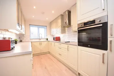 a kitchen with white cabinets and a black appliance at Ideal Contractor & Family Stay-Basildon Smart tv in Nevendon
