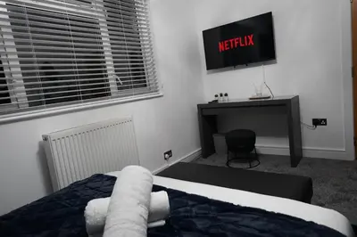 a bedroom with a bed and a desk and a television at Premium 3BR House - Loughton - by Rent Squared LTD in Loughton