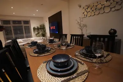 a dining room table with plates and glasses on it at Premium 3BR House - Loughton - by Rent Squared LTD in Loughton