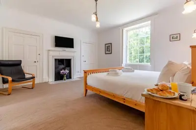 a bedroom with a bed and a table with a plate of bread at 9 Bed in Three Holes oc-l31856 in Upwell