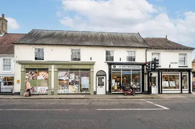 a white building on the corner of a street at Flat Two, High Street in Saxmundham