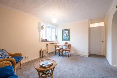 a living room with a table and chairs at Flat Two, High Street in Saxmundham