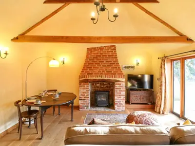 a living room with a couch and a fireplace at The Old Cow Shed in Eye