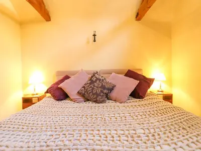 a bedroom with a large bed with many pillows at The Old Cow Shed in Eye