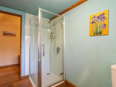 a shower with a glass door in a bathroom at The Old Cow Shed in Eye