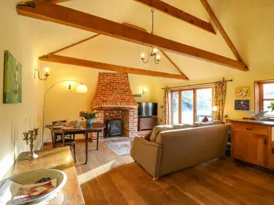 a living room with a couch and a fireplace at The Old Cow Shed in Eye