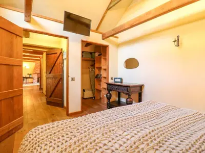 a bedroom with a bed and a desk in it at The Old Cow Shed in Eye