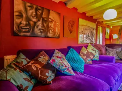 a purple couch in a room with pictures on the wall at Town Farm in Eye
