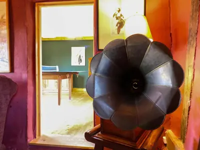 a room with a table and a lamp and a fan at Town Farm in Eye