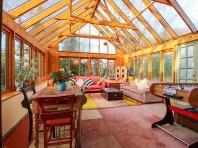 a conservatory with a glass roof with a living room at Town Farm in Eye