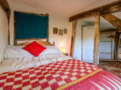 a bedroom with a large bed with a red pillow at Town Farm in Eye