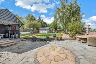 a backyard with a patio with a fire pit at Luxury Spa Mansion With Heated Pool and Spa Facilities in Stanningfield