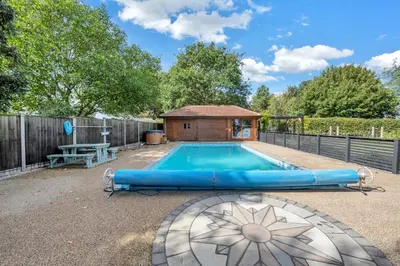 a swimming pool with a gazebo in a backyard at Luxury Spa Mansion With Heated Pool and Spa Facilities in Stanningfield