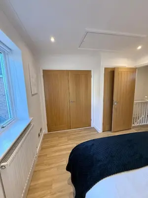 a bedroom with a bed and some wooden cabinets at The Waldegraves Hideaway in Bures Saint Mary