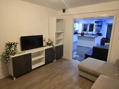 a living room with a flat screen tv and a couch at Optimal Homes in Harold Wood
